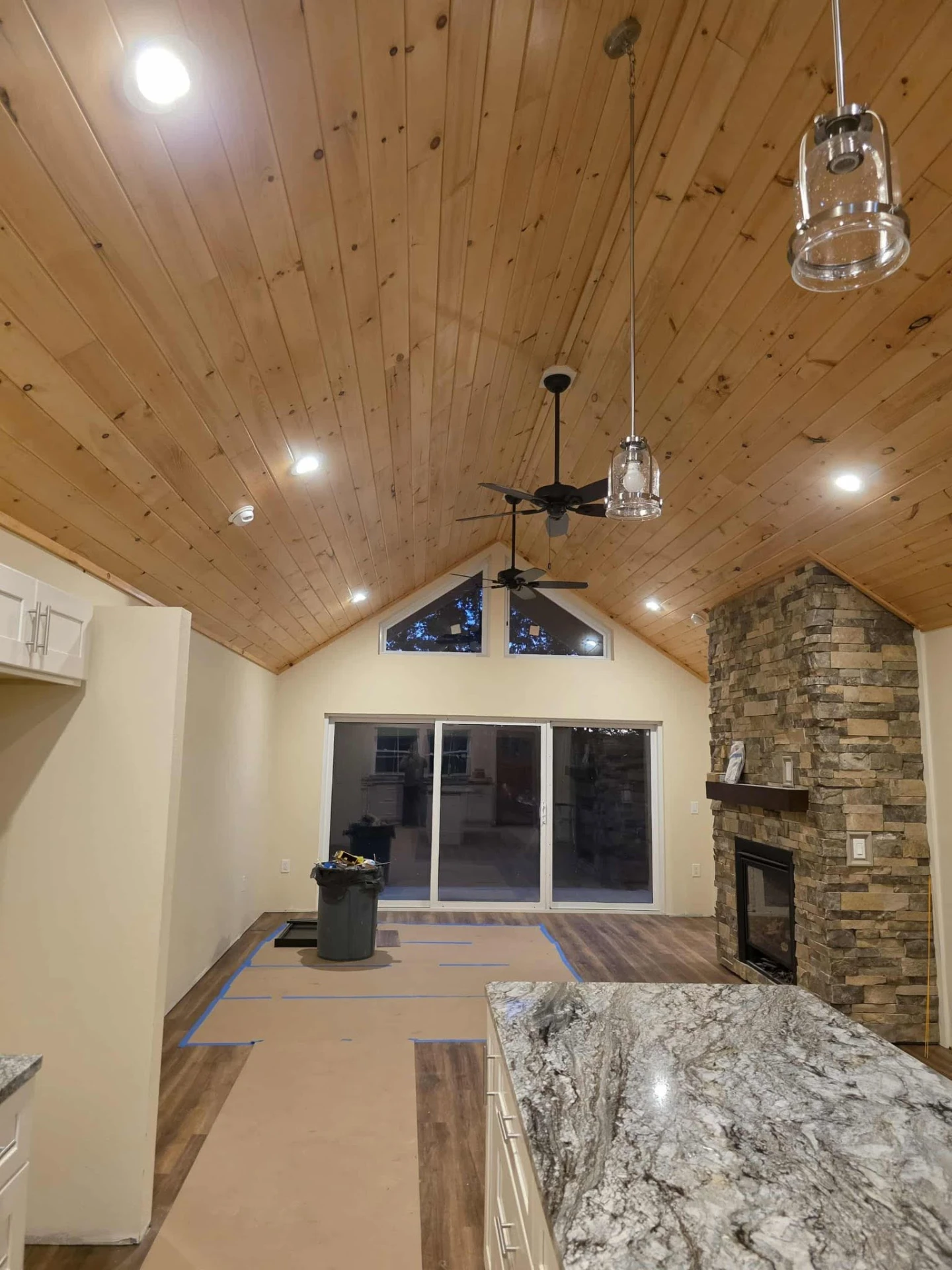 Vaulted wood ceiling with recessed and pendant lighting